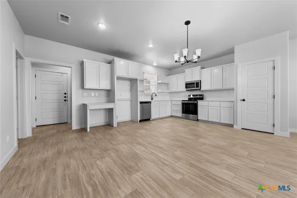 a kitchen with granite countertop a refrigerator and a stove