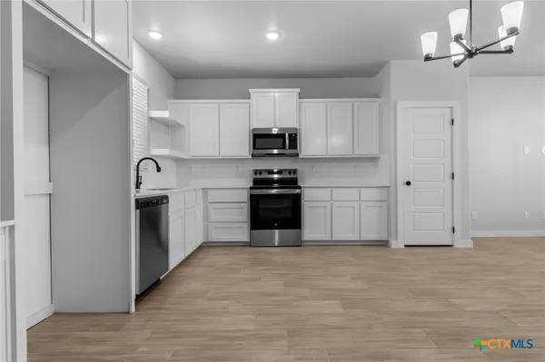 a kitchen with stainless steel appliances sink a microwave and cabinets