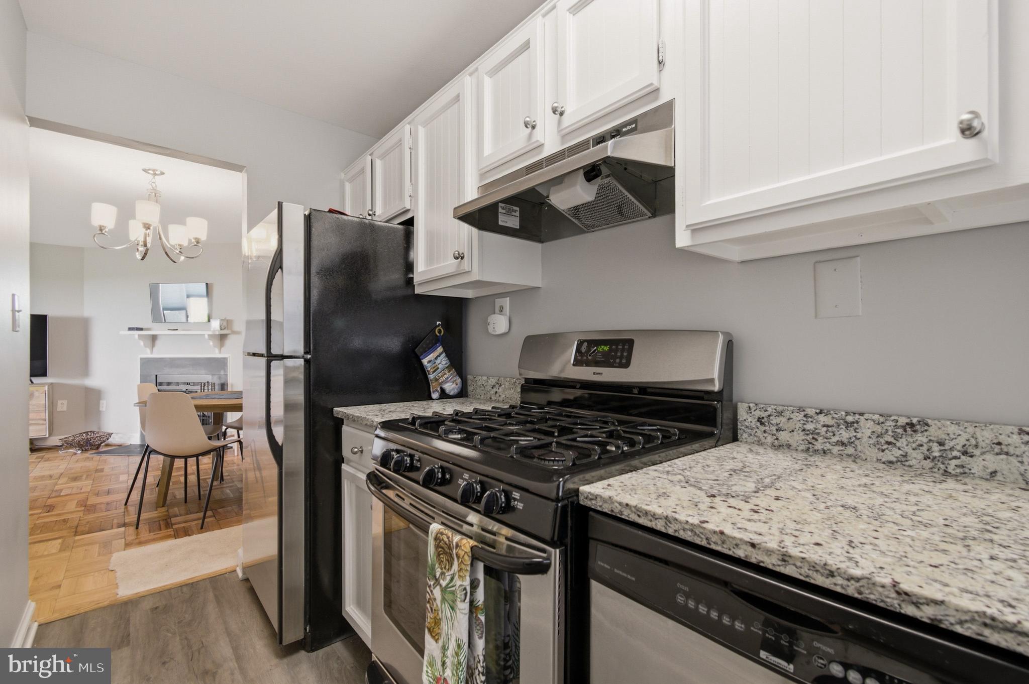 2606 Tunlaw Road Northwest, Unit 2 Washington, DC 20007 - Photo 10 of 14 a kitchen with granite countertop a stove and a refrigerator
