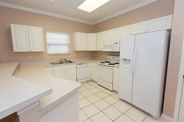 a kitchen with white cabinets and white appliances