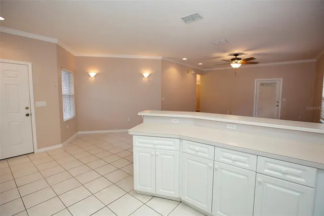 a view of a hallway with closet and chandelier fan