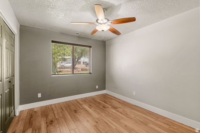 55 Spring Drive Toquerville, UT 84774 - Photo 18 of 36 Unfurnished bedroom 2 with a closet, light wood-type flooring, a ceiling fan, and a textured ceiling