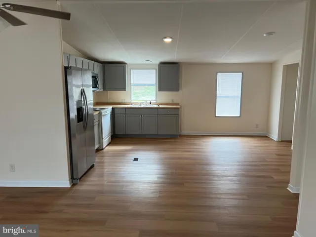 a kitchen with stainless steel appliances granite countertop a refrigerator and a stove top oven