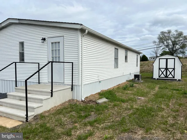 a view of a white house in front of a yard
