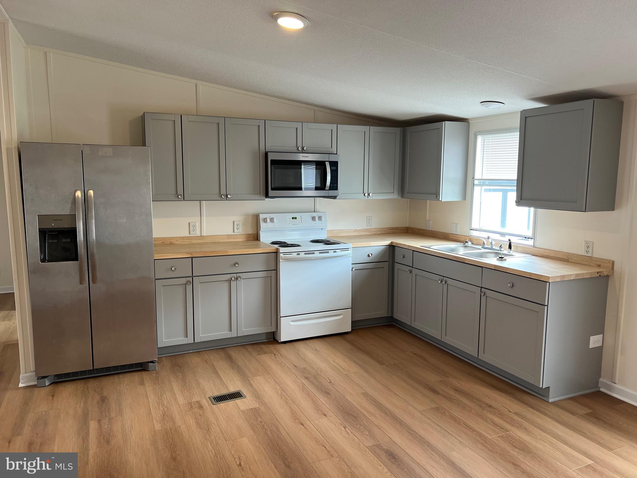 65 Dugan Court Hedgesville, WV 25427 - Photo 3 of 14 a kitchen with a sink cabinets stainless steel appliances and a window