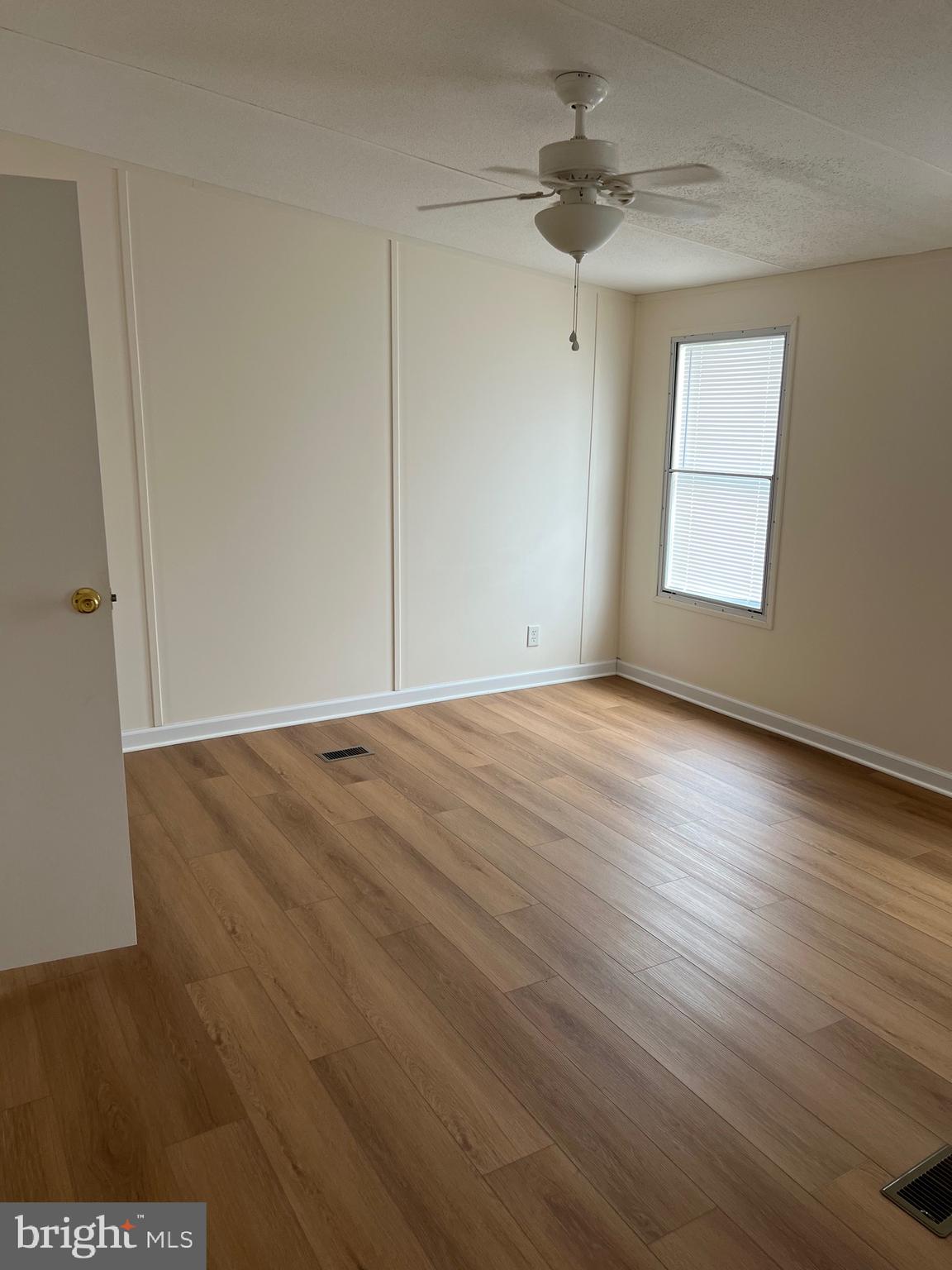 65 Dugan Court Hedgesville, WV 25427 - Photo 4 of 14 wooden floor in an empty room with a window