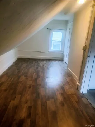 en empty room with wooden floor and window