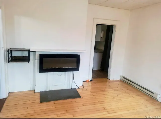 a view of a livingroom with wooden floor and a flat screen tv