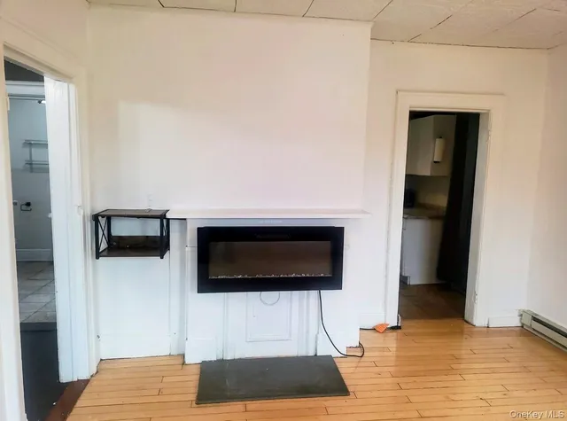a living room with a wooden floor and a view of hallway