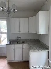 a kitchen with stainless steel appliances granite countertop a sink a stove and white cabinets
