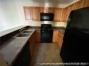 a kitchen with a sink and a stove top oven with wooden floor