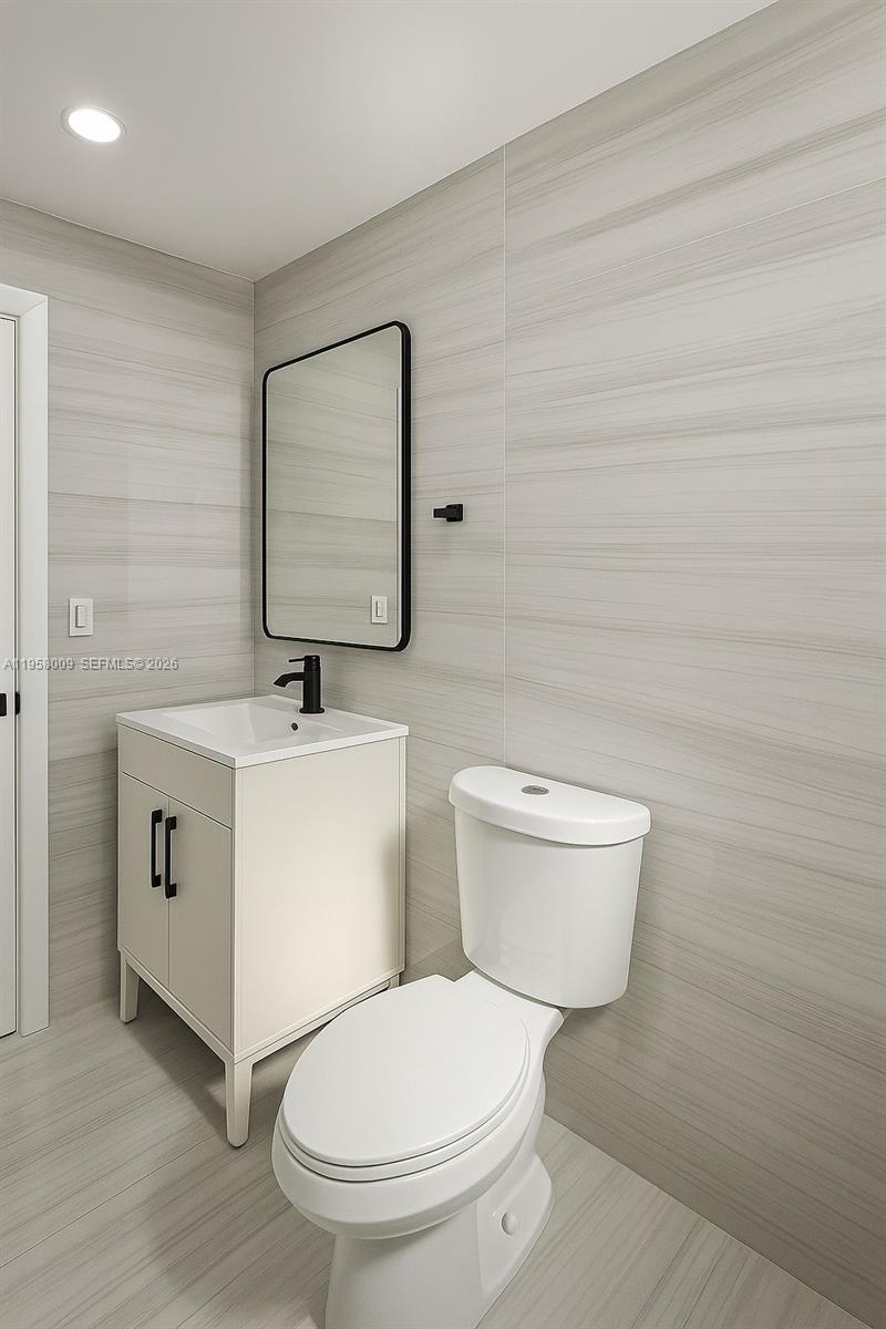 5740 Mayo Street, Unit 4 Hollywood, FL 33023 - Photo 4 of 10 a white toilet sitting next to a bathroom sink
