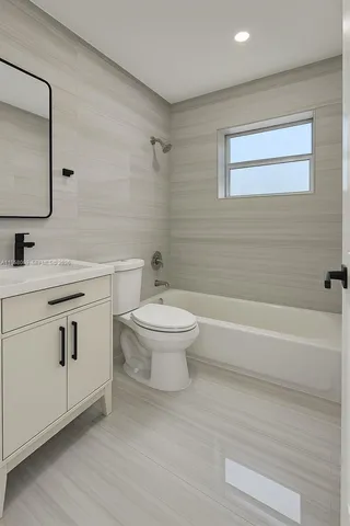 a bathroom with a toilet a sink a mirror and bathtub