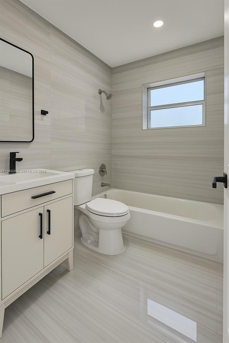 5740 Mayo Street, Unit 4 Hollywood, FL 33023 - Photo 6 of 10 a bathroom with a toilet a sink a mirror and bathtub