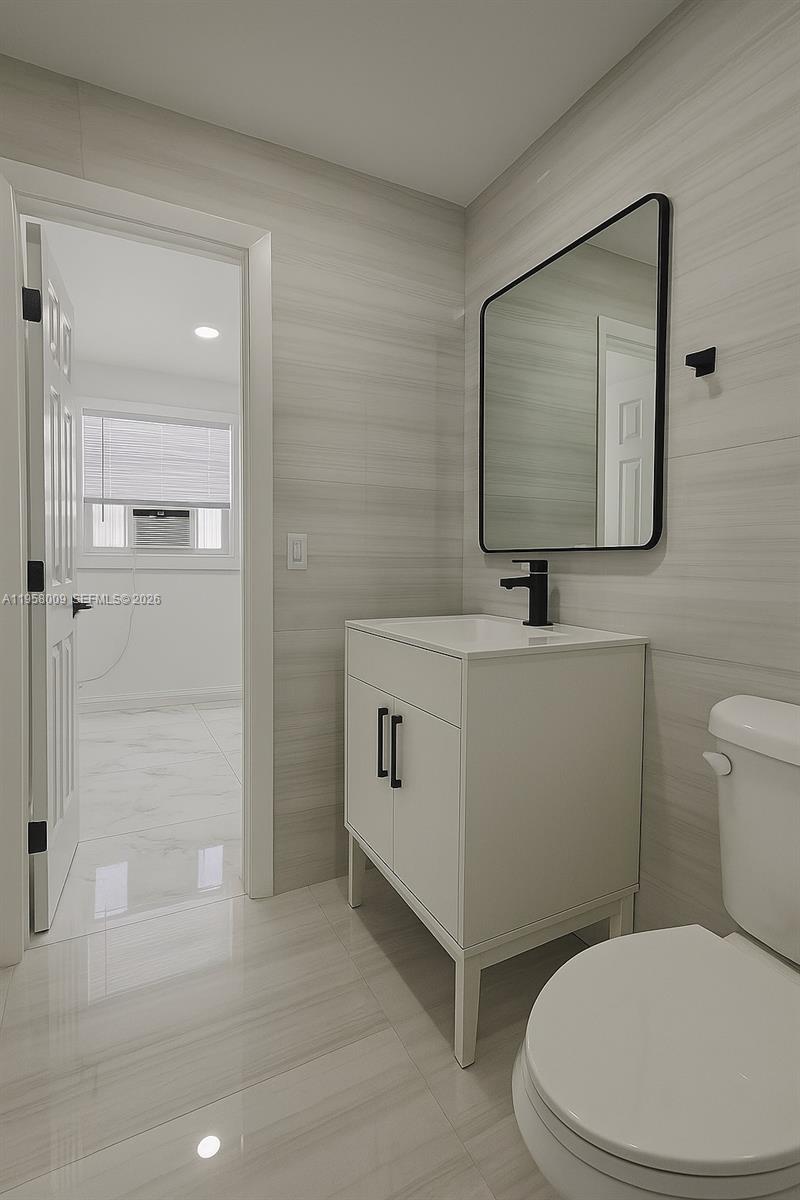 5740 Mayo Street, Unit 4 Hollywood, FL 33023 - Photo 8 of 10 a bathroom with a toilet sink and mirror