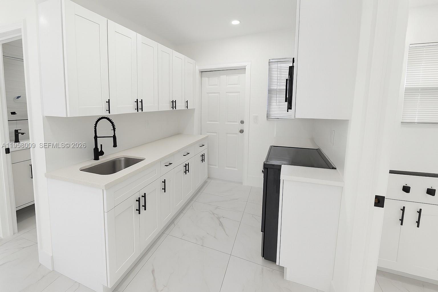 5740 Mayo Street, Unit 4 Hollywood, FL 33023 - Photo 10 of 10 a kitchen with stainless steel appliances a sink a stove and white cabinets