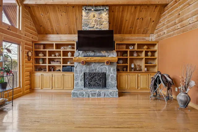 a living room with furniture large windows and wooden floor