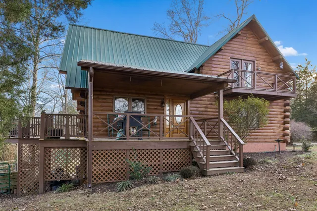 a living room with furniture a fireplace a flat screen tv and windows