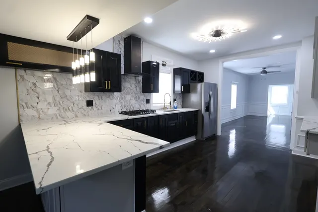 a kitchen with stainless steel appliances sinks a counter top space cabinets and wooden floor