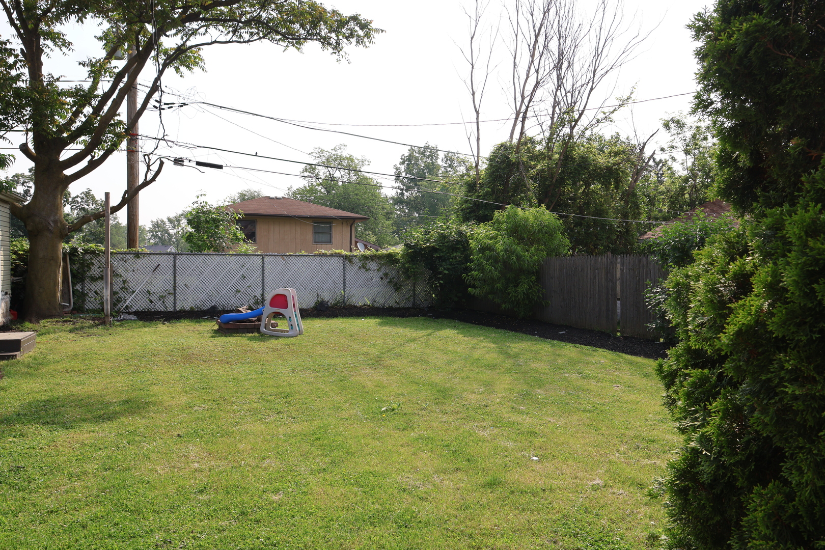 15239 Vincennes Road Phoenix, IL 60426 - Photo 4 of 24 a view of a backyard with table and chairs and wooden fence