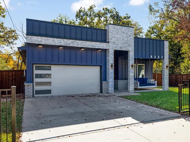 a view of a house with a small yard and wooden fence