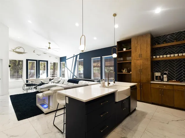 a large kitchen with a large counter top space appliances and a sink