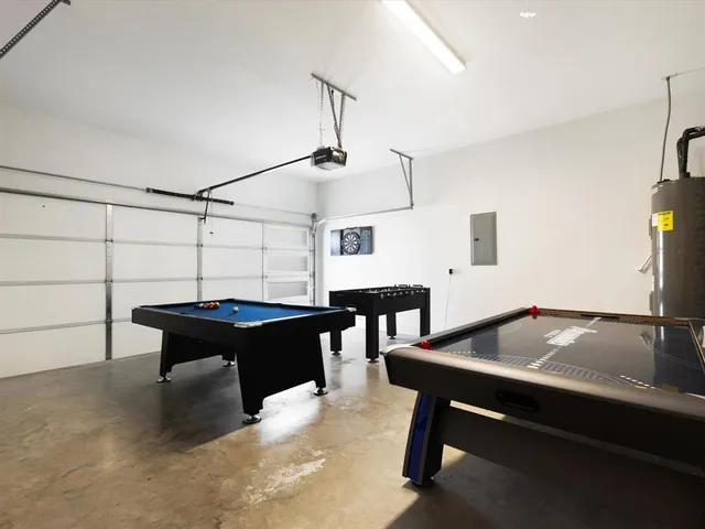 a living room with table chairs and a potted plant