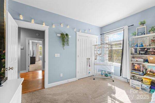 1761 Lakeland Trail Drive Tega Cay, SC 29708 - Photo 31 of 46 a view of a livingroom with wooden floor and a bookshelf