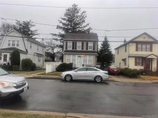 a car parked in front of a white house