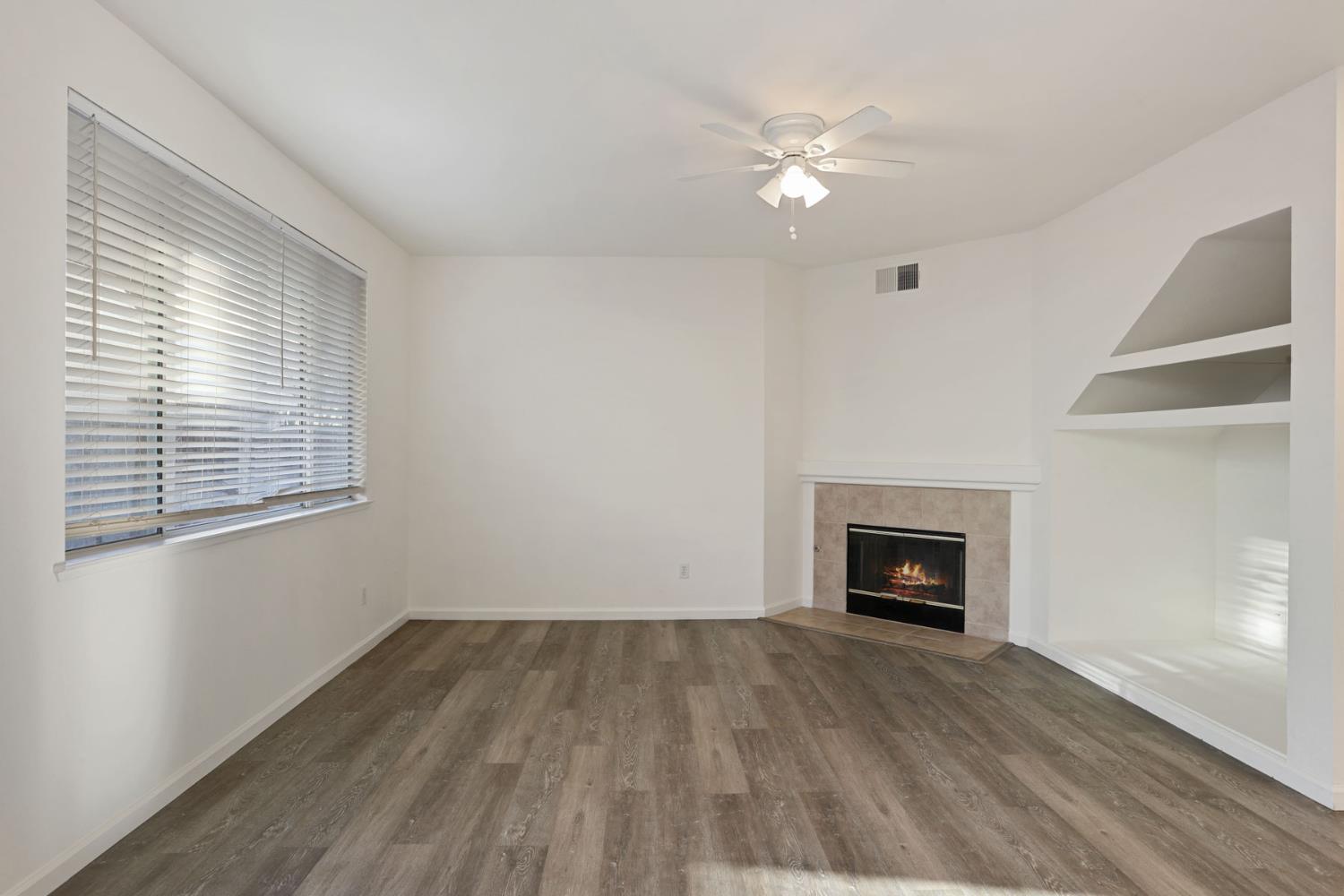 4882 Timepiece Circle Stockton, CA 95219 - Photo 14 of 43 an empty room with a fireplace and wooden floor