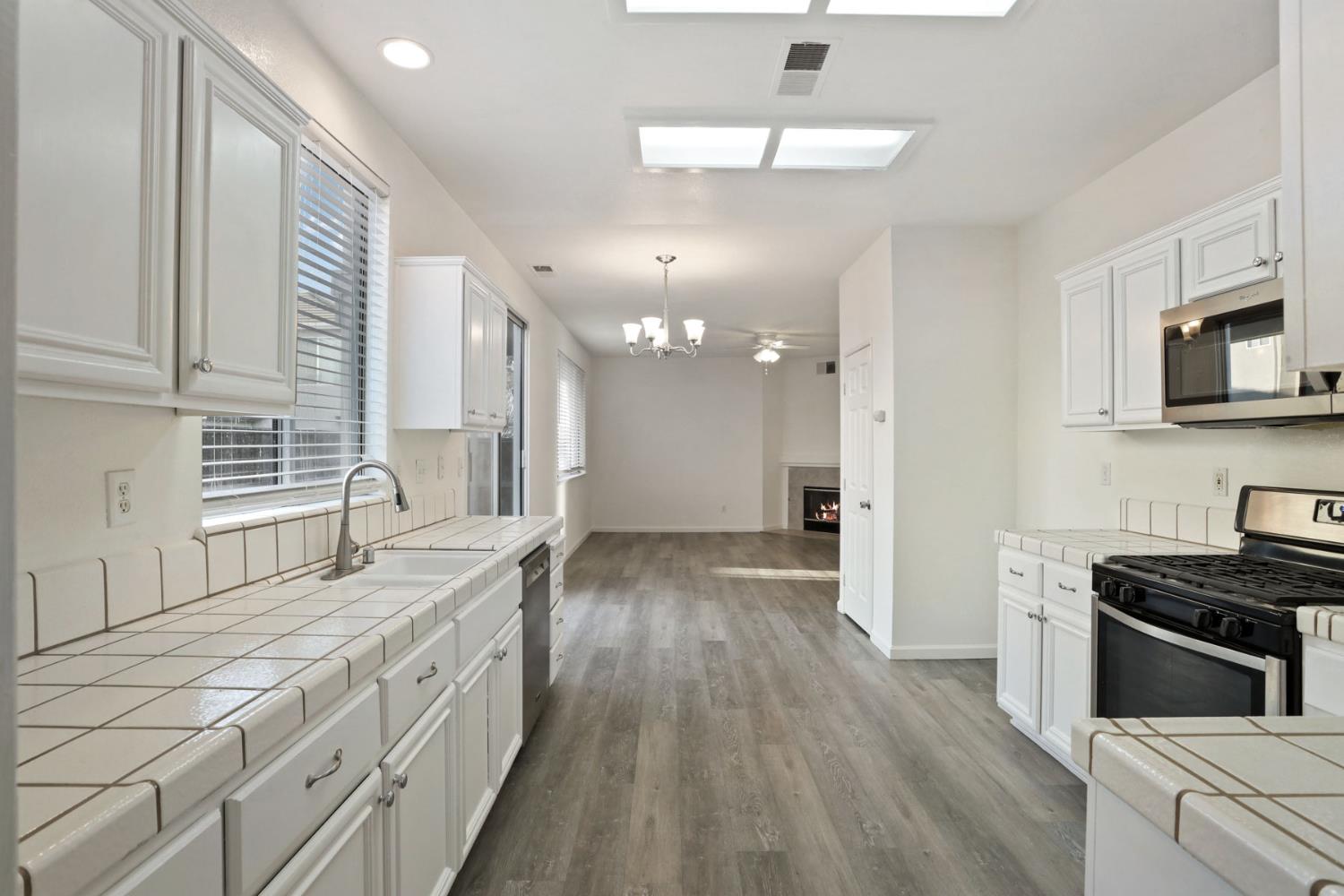 4882 Timepiece Circle Stockton, CA 95219 - Photo 22 of 43 a kitchen with granite countertop a stove a sink and a refrigerator