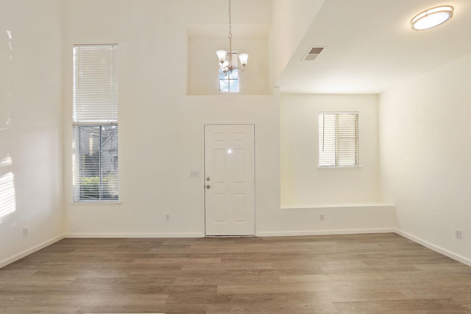 4882 Timepiece Circle Stockton, CA 95219 - Photo 10 of 43 an empty room with wooden floor and windows