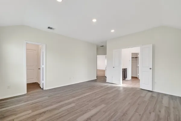 a view of empty room with wooden floor