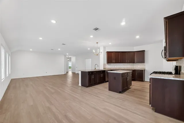 a view of kitchen with kitchen island stainless steel appliances a sink and a stove