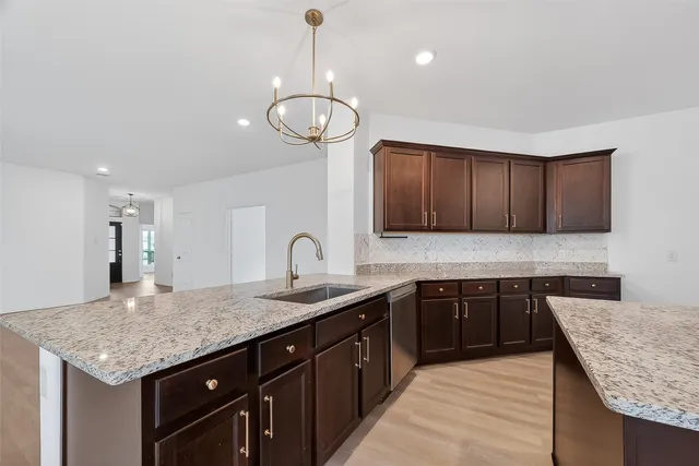 a kitchen with stainless steel appliances granite countertop wooden cabinets a sink and dishwasher