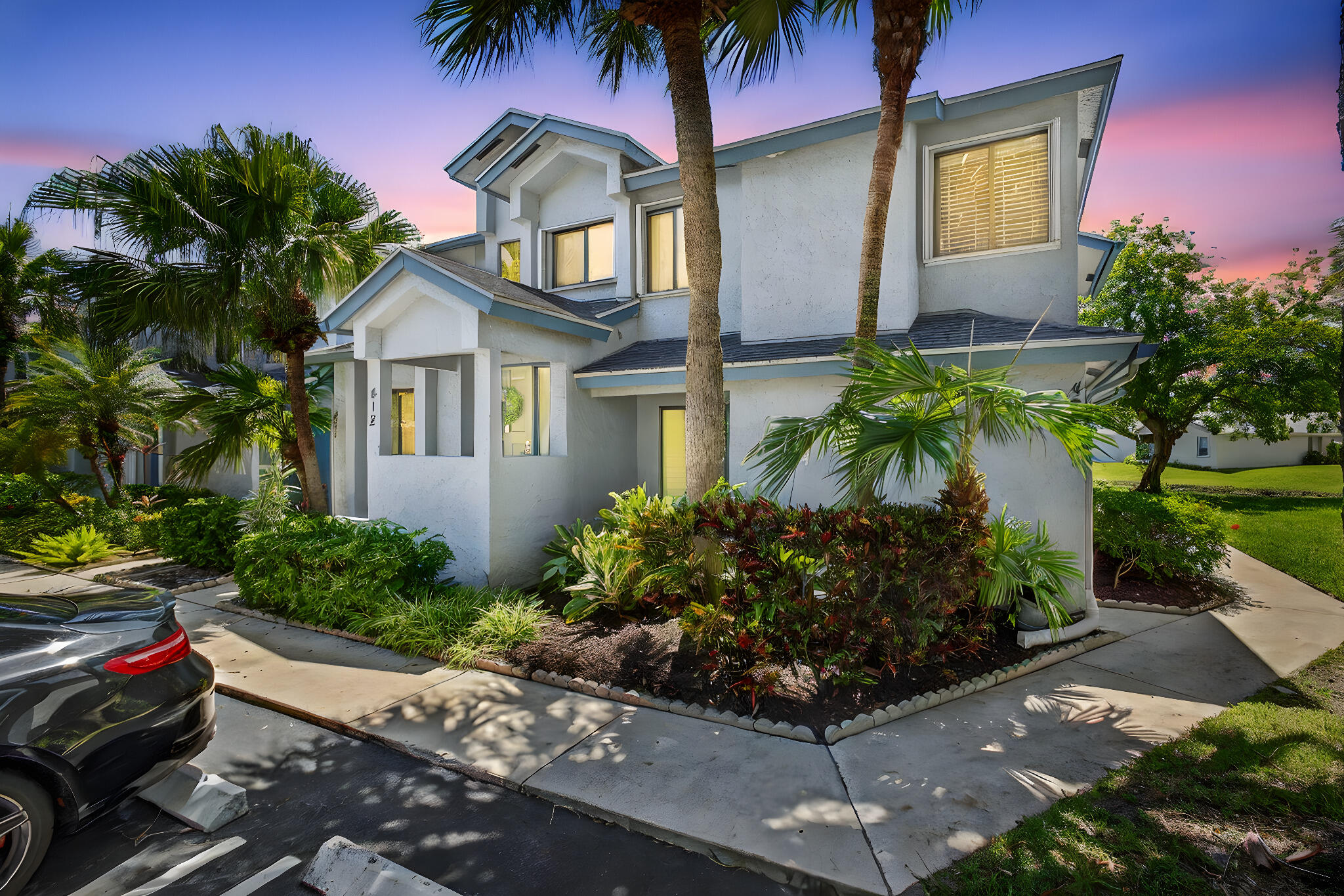 a front view of a house with a yard and potted plants
