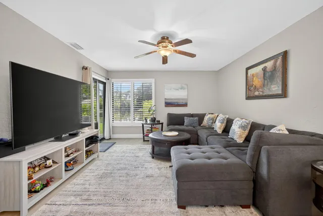 a kitchen with stainless steel appliances granite countertop white cabinets a sink a stove a refrigerator and dishwasher with wooden floor