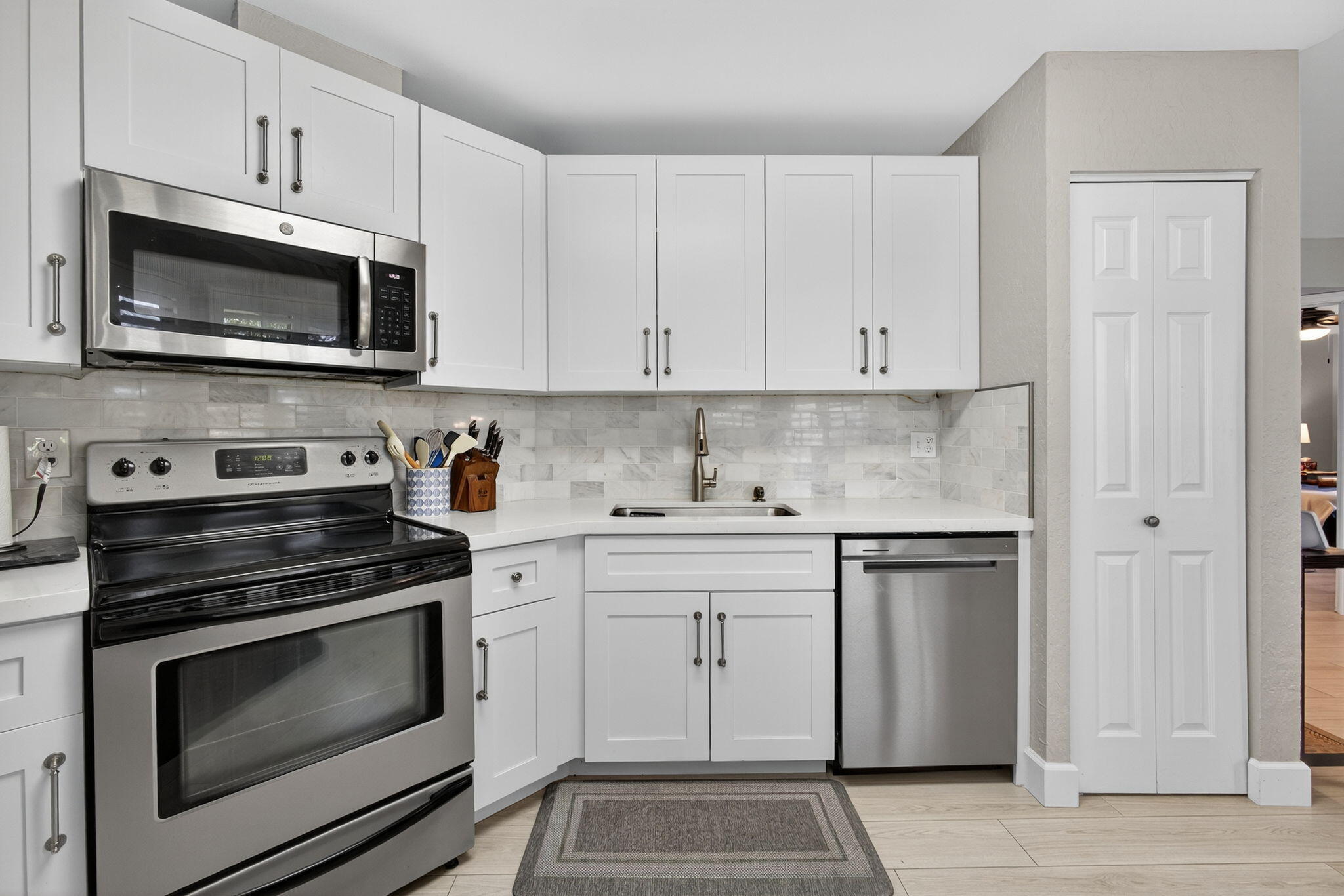 406 Harbour Pointe Way Greenacres, FL 33413 - Photo 29 of 79 a kitchen with white cabinets and stainless steel appliances
