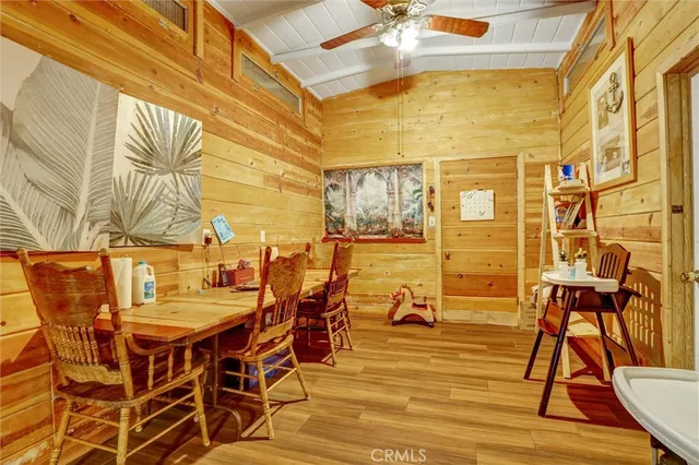 a dining room with stainless steel appliances kitchen island granite countertop a table chairs and a rug