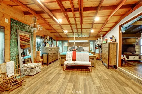 a bedroom with a bed a couch and a chandelier