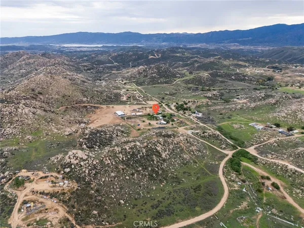 an aerial view of house with yard and mountain view in back