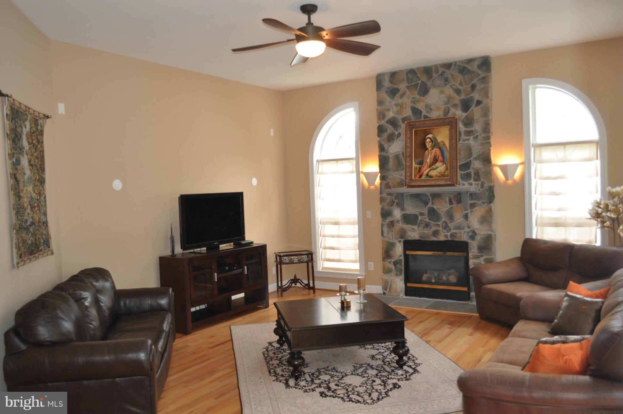 3907 Pender Spring Drive Fairfax, VA 22033 - Photo 6 of 30 a living room with furniture a fireplace and a flat screen tv