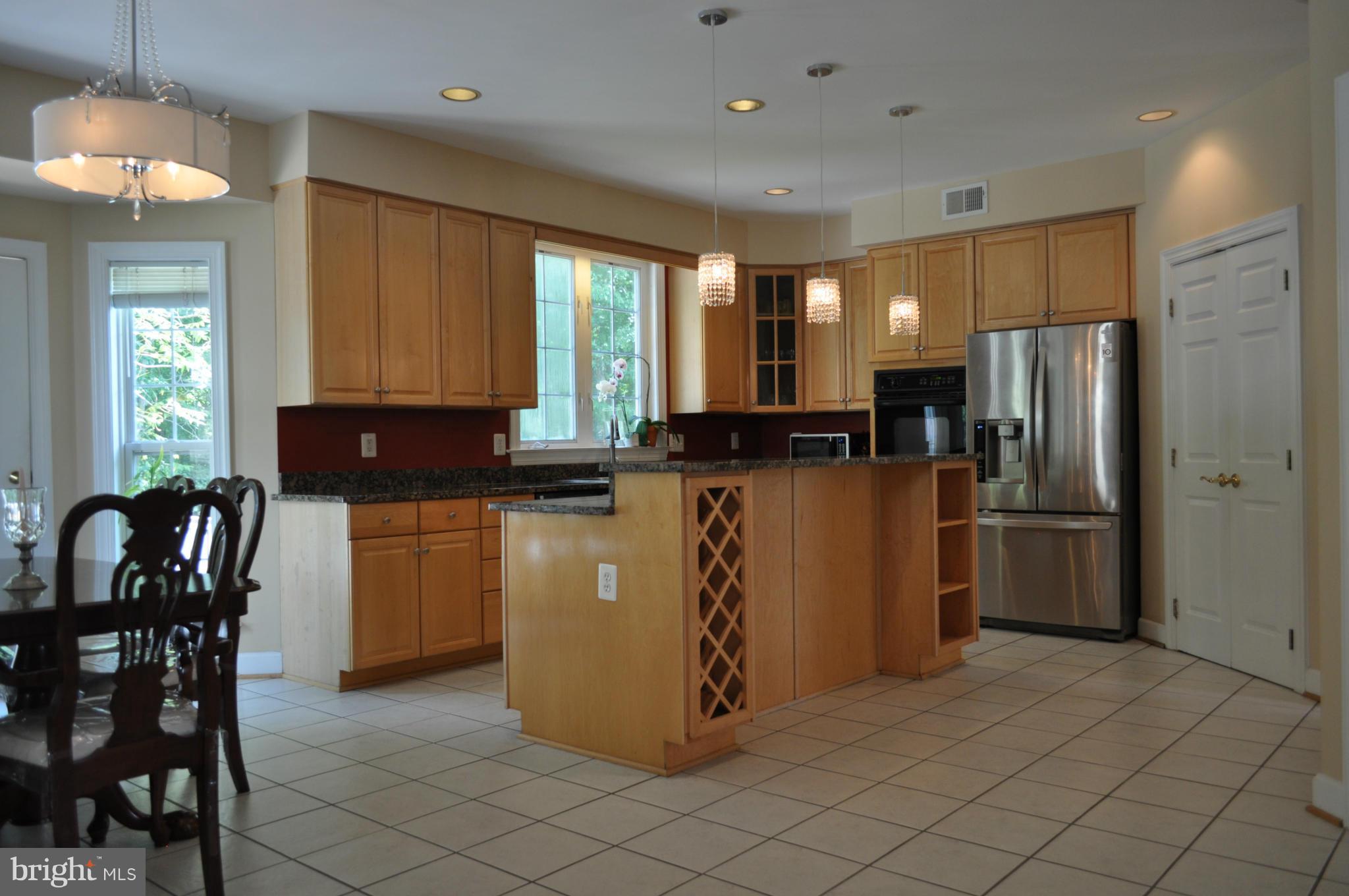 3907 Pender Spring Drive Fairfax, VA 22033 - Photo 9 of 30 a kitchen with stainless steel appliances granite countertop a refrigerator a stove a sink a dining table and chairs