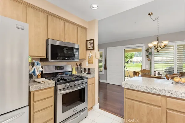 a kitchen with granite countertop a sink a counter top space stainless steel appliances and cabinets