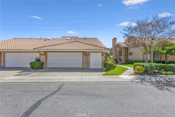 a front view of a house with a garden and plants