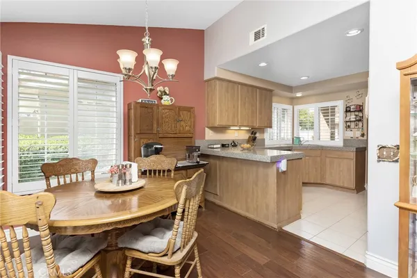 a kitchen with a dining table chairs and refrigerator