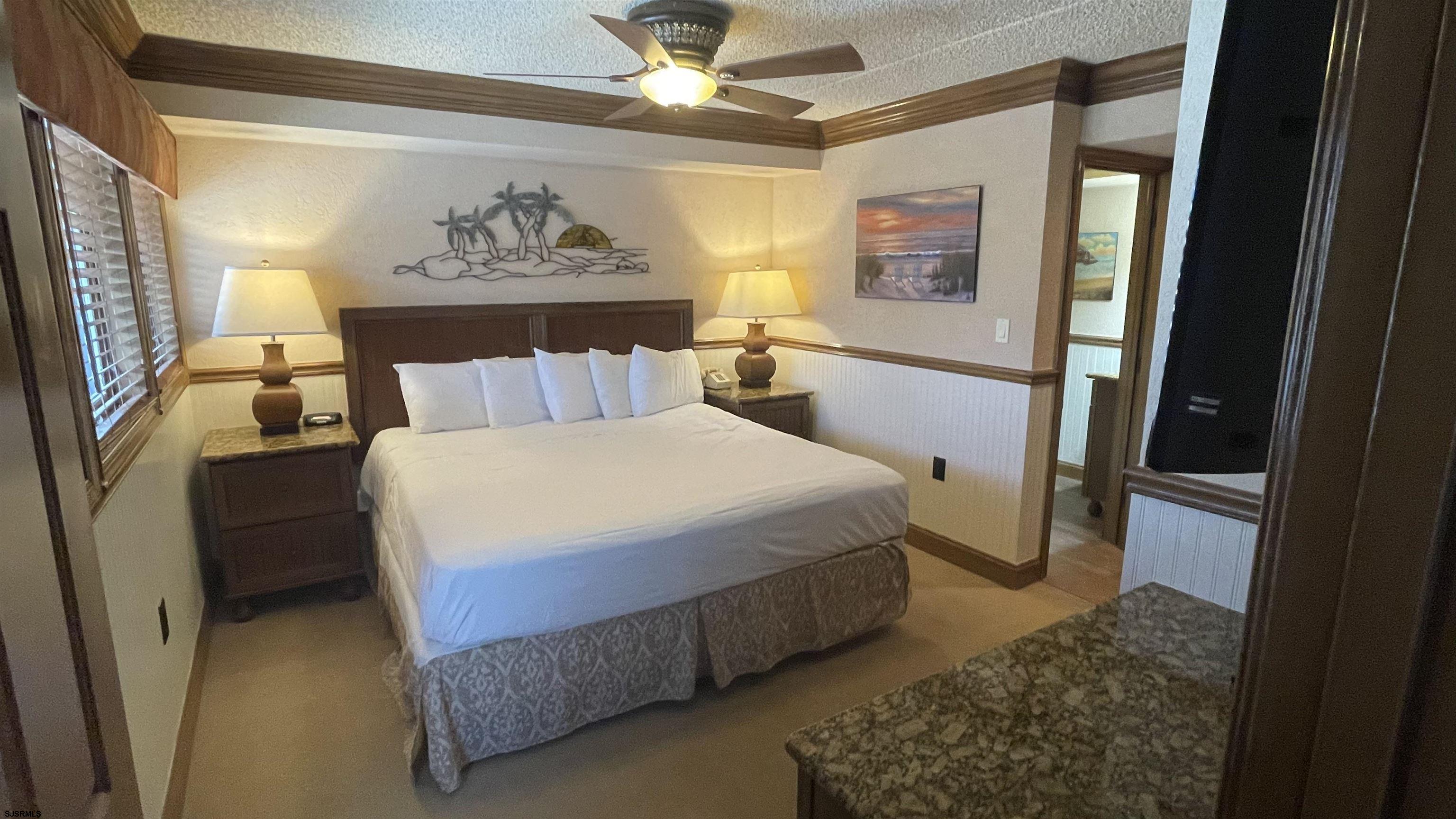 820 Ocean Avenue, Unit 115 Ocean City, NJ 08226 - Photo 22 of 58 a bedroom with a bed and a painting on the wall