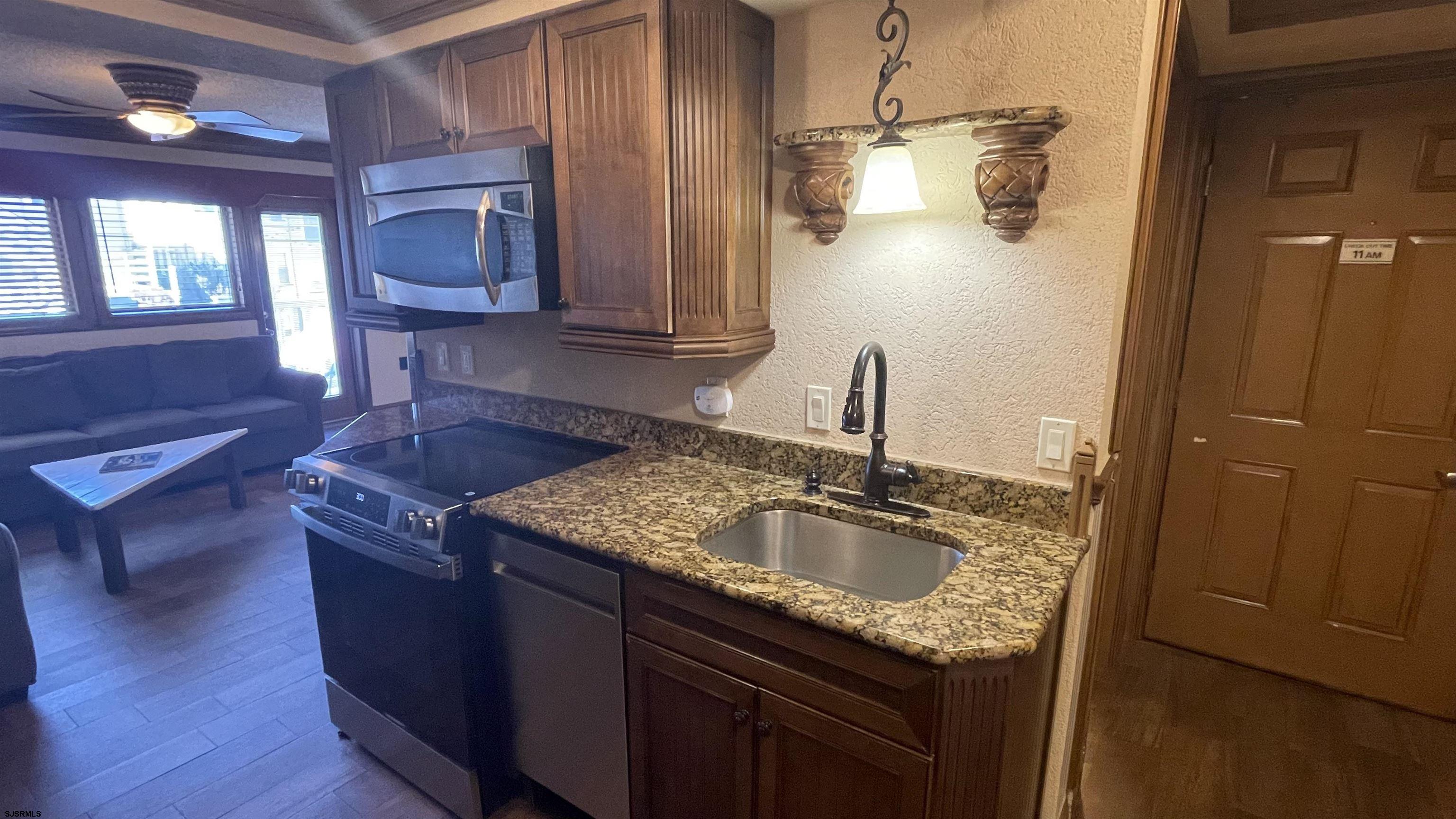 820 Ocean Avenue, Unit 115 Ocean City, NJ 08226 - Photo 43 of 58 a kitchen with granite countertop a sink a stove and cabinets