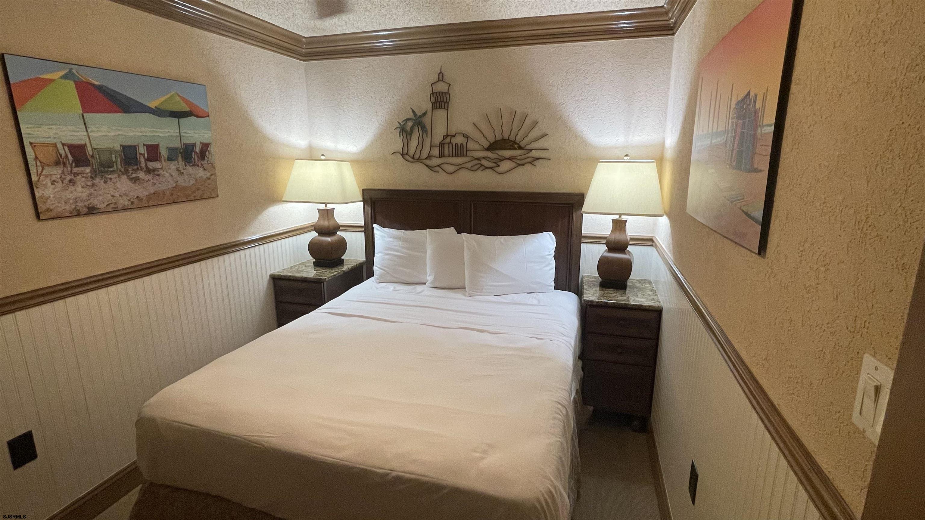 820 Ocean Avenue, Unit 115 Ocean City, NJ 08226 - Photo 49 of 58 a bed room with a bed and a painting on the wall