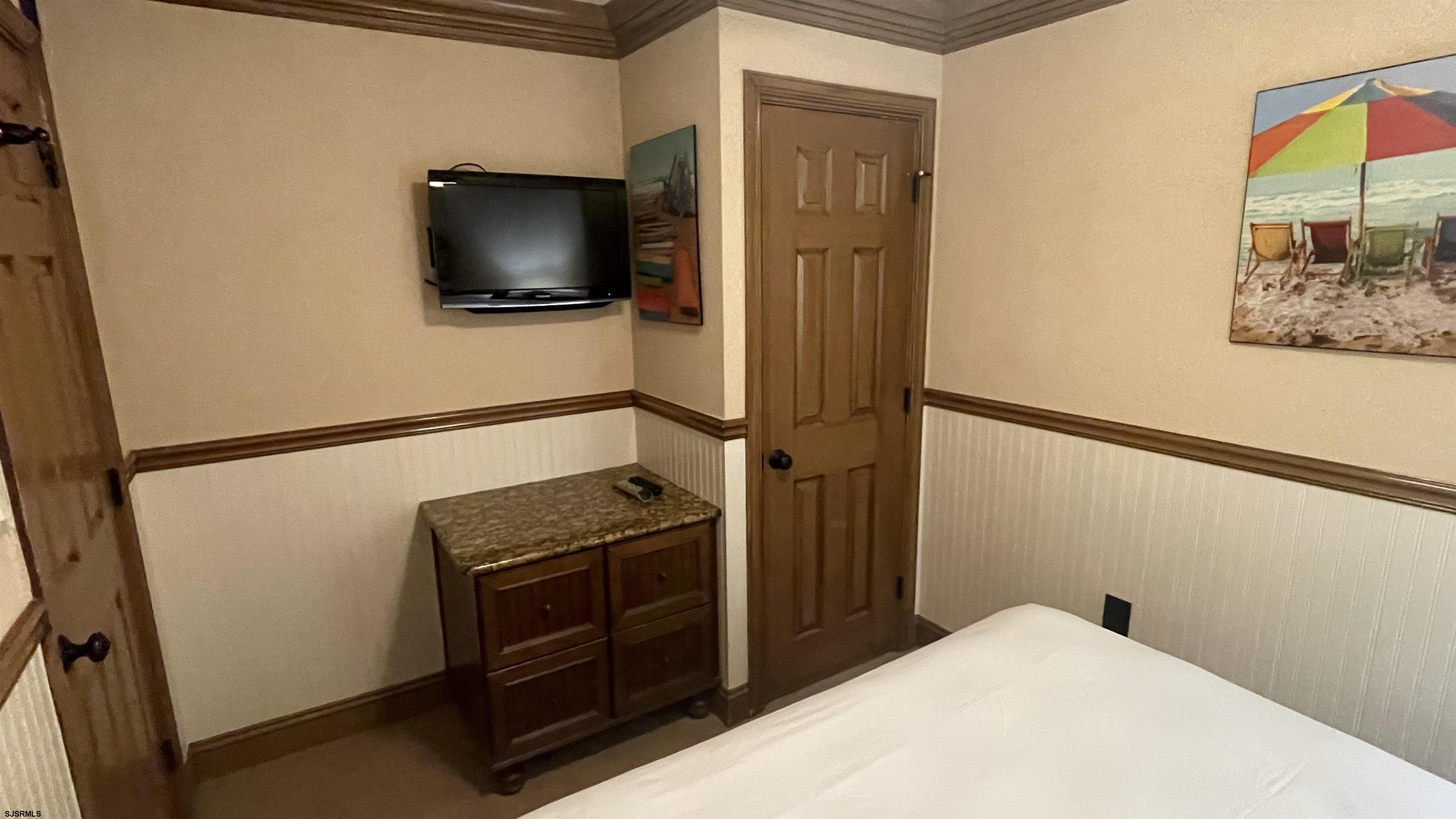 820 Ocean Avenue, Unit 115 Ocean City, NJ 08226 - Photo 50 of 58 a view of a livingroom with wooden floor and flat screen tv